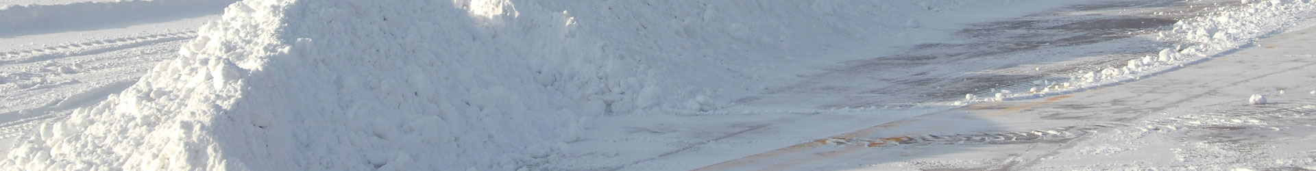 Cleared snow accumulation along a commercial roadway
