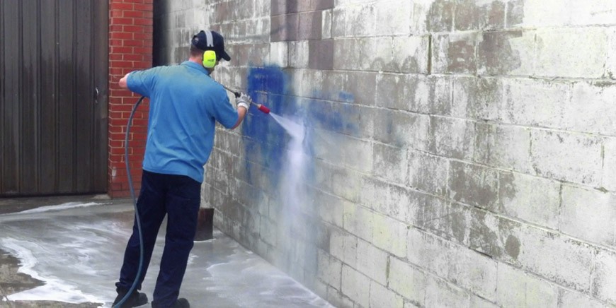 Pressure washing a masonry wall
