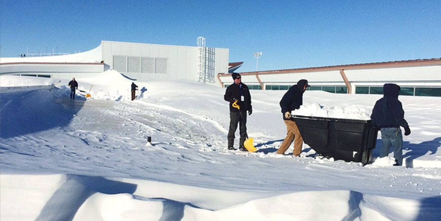 Snow-removal crew working on a commercial rooftop